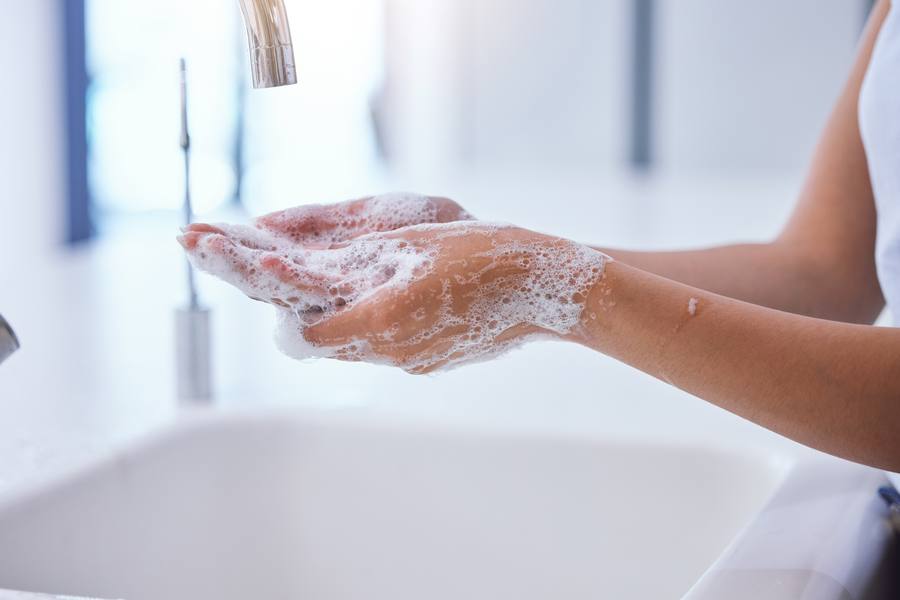Hands being washed under a running tap